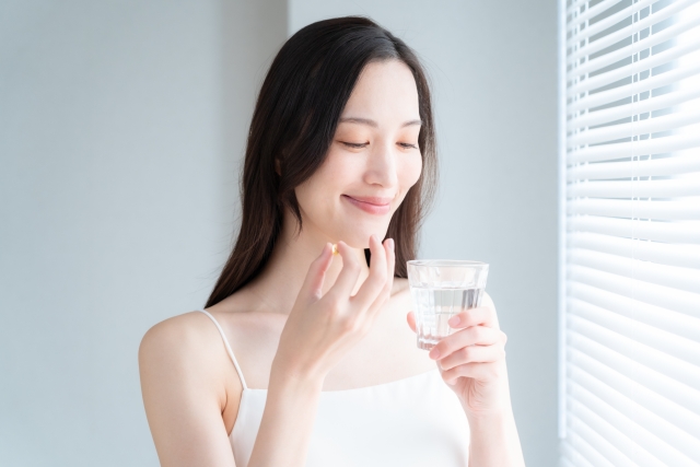 サプリメントを飲む女性